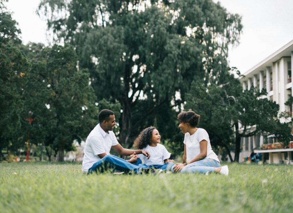 pexels-photo-1128316-1128316 A happy black family enjoying quality time together outdoors in a lush green park.